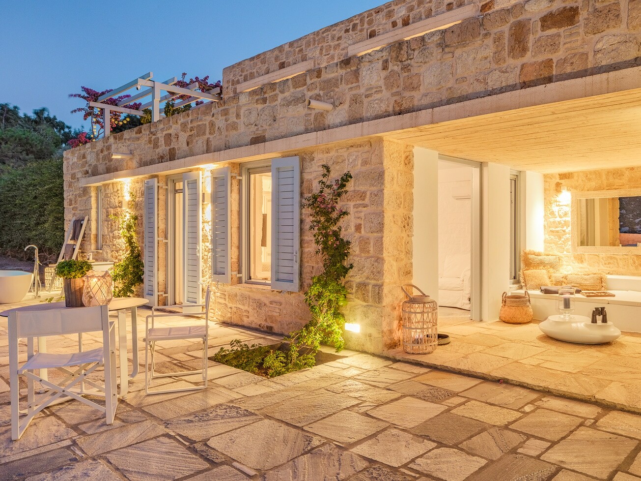 Evening view of stone villa and terrace at Patmos Luxury Escape