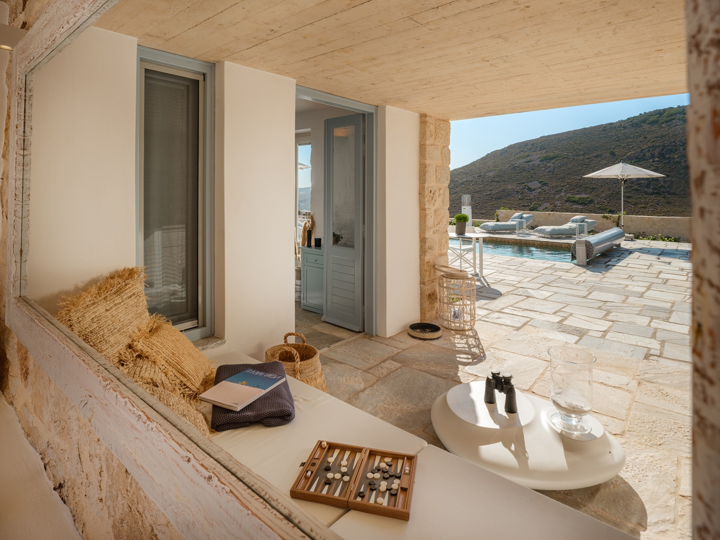 Covered outdoor lounge with sofa and dining table at Patmosphere