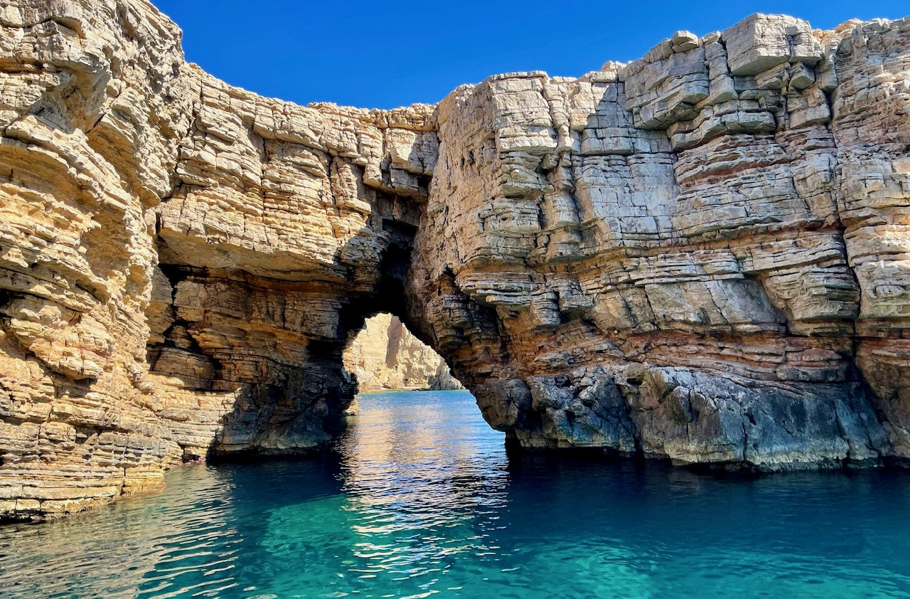 Historic Patmos windmill by the sea with blue sky backdrop