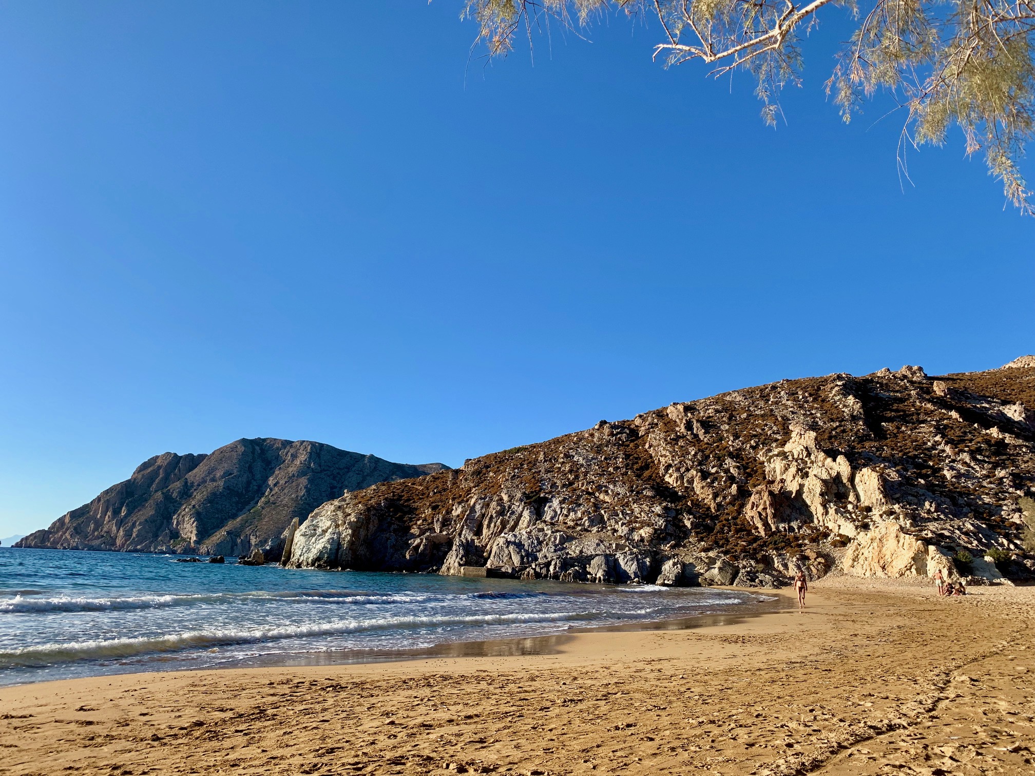 Sandy beach with turquoise waters and rocky cliffs in Patmos island – perfect day by the sea