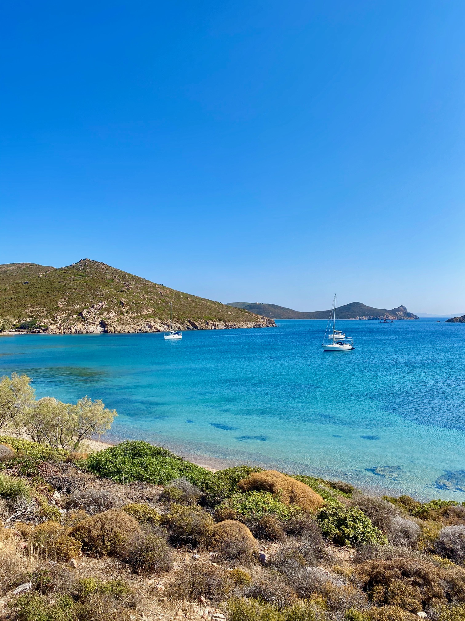 Anchored sailing boats in turquoise bay on Patmos island