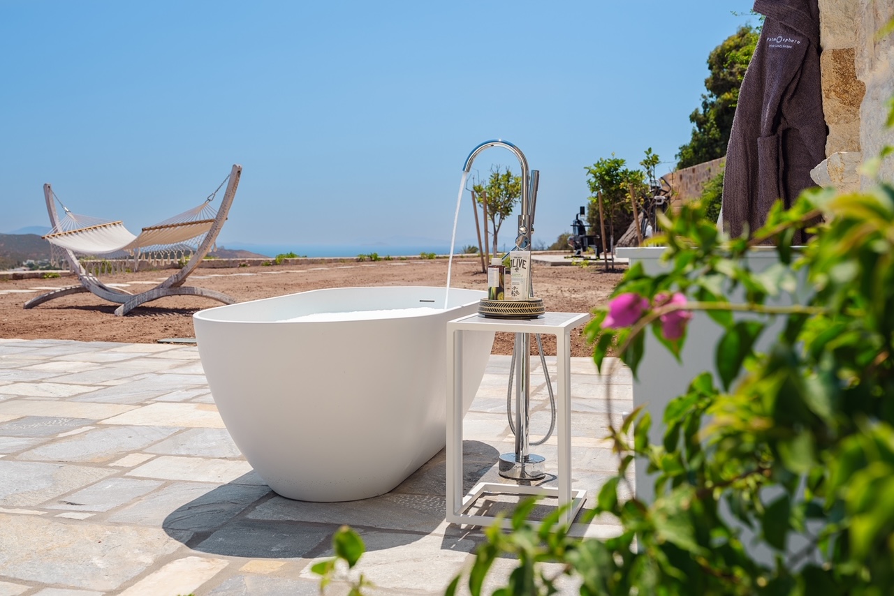 Outdoor stone bathtub with hammock and sea views at Patmosphere Luxury Escape villa