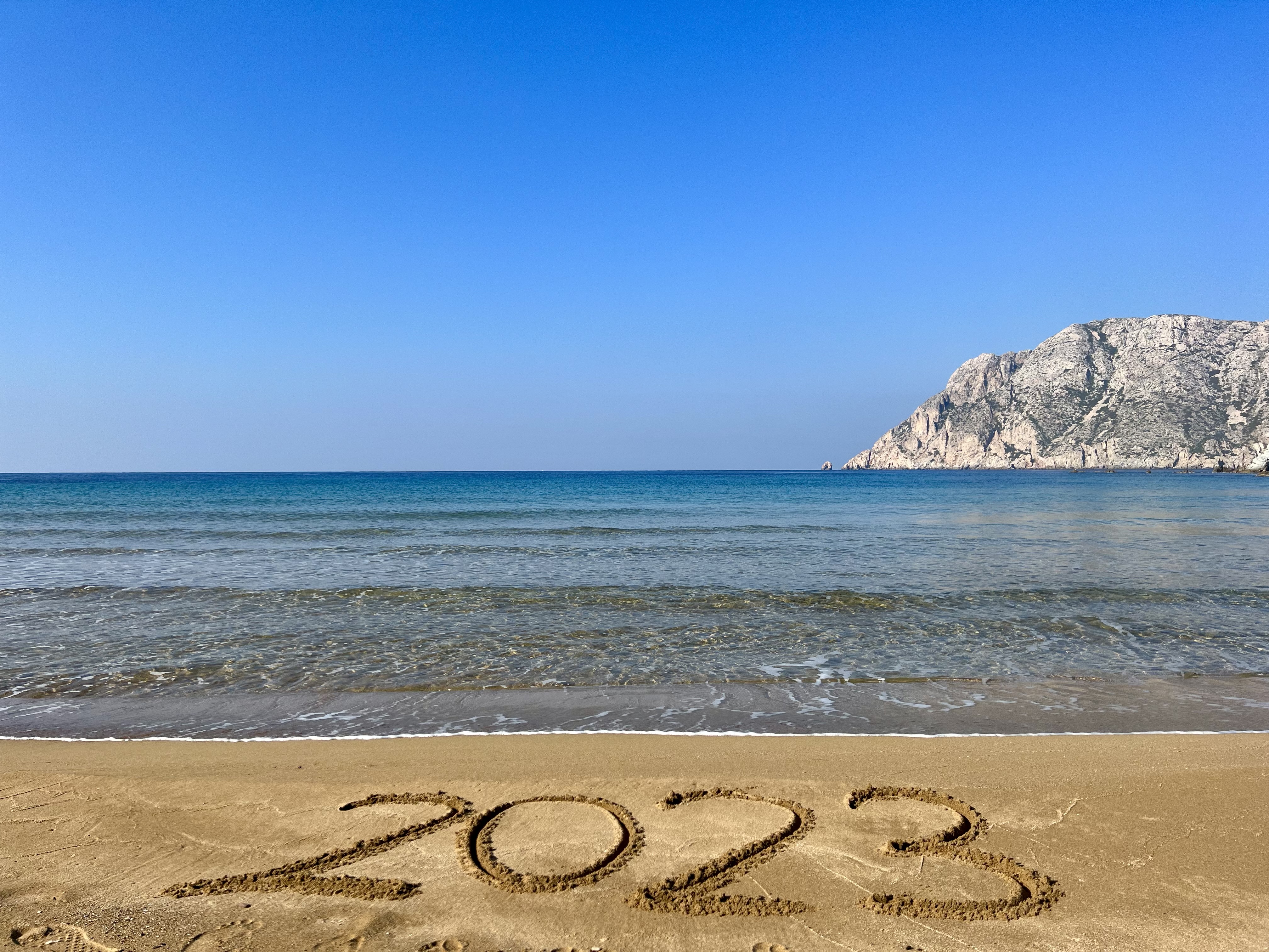 Sandy beach in Patmos with “2023” written in the sand