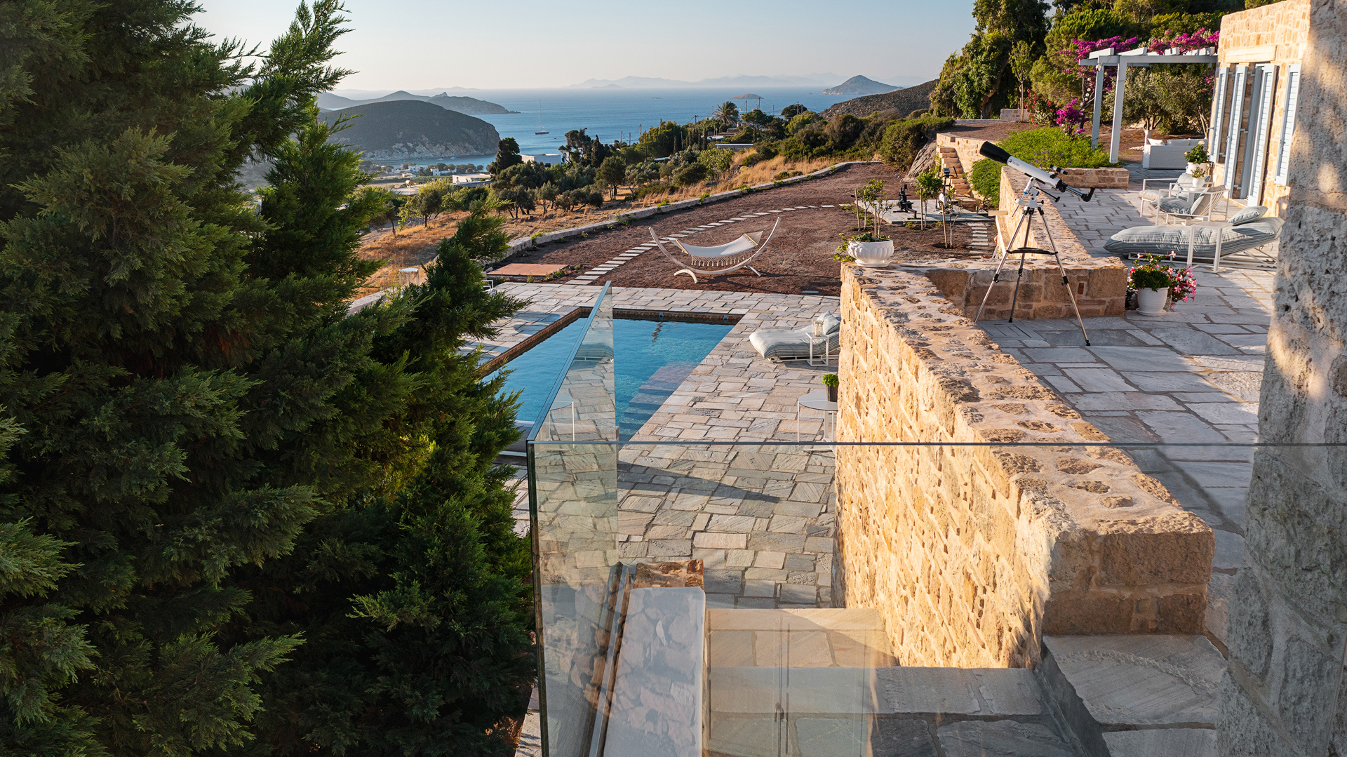 Elevated view of salt-water pool and stone villa at Patmosphere Luxury Escape