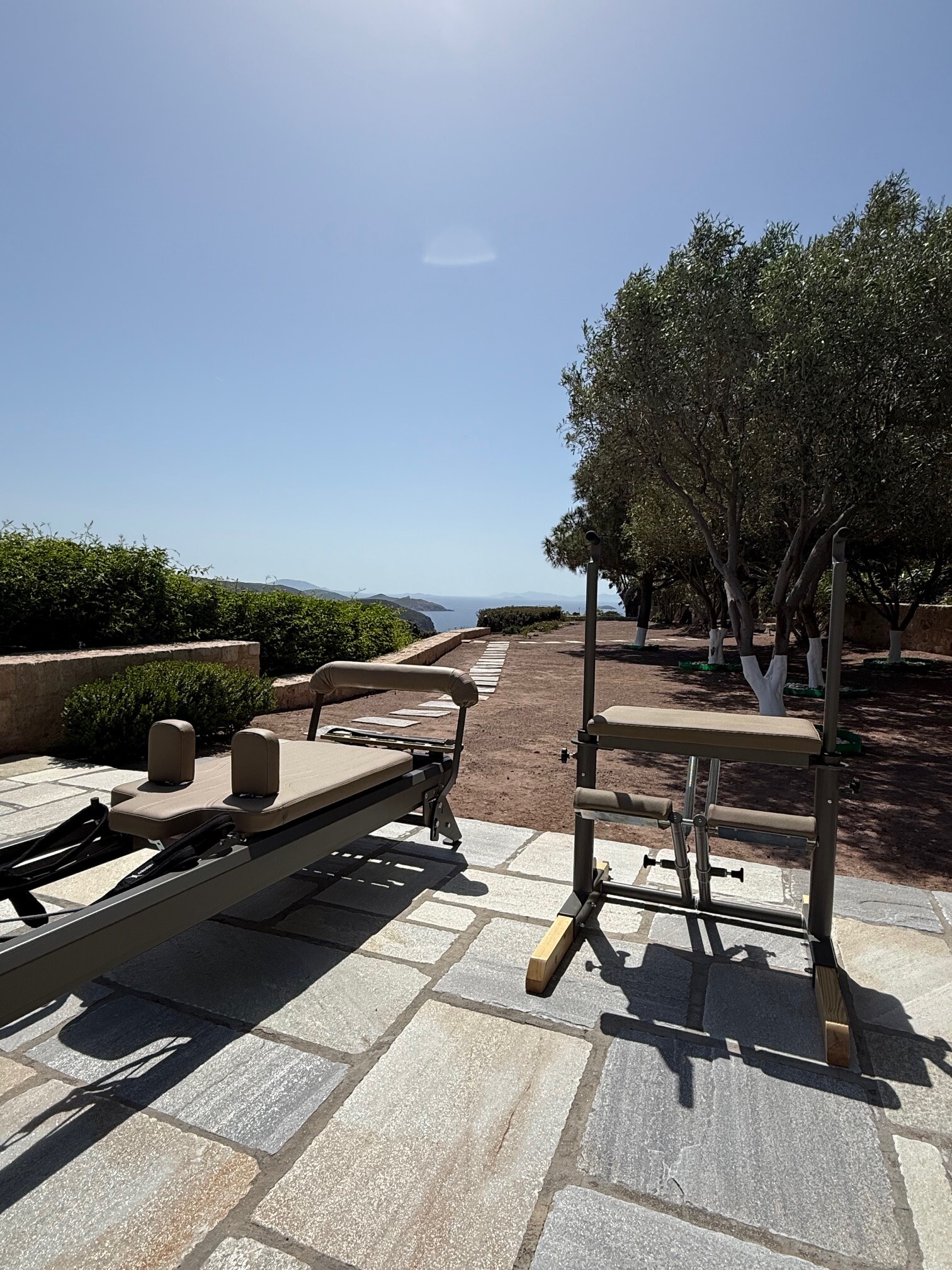 Terrace view of Pilates reformer machines under the morning sun in Patmos