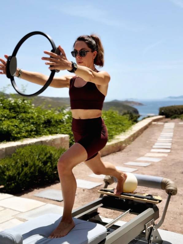Pilates reformer exercise with fitness instructor at outdoor studio in Patmos
